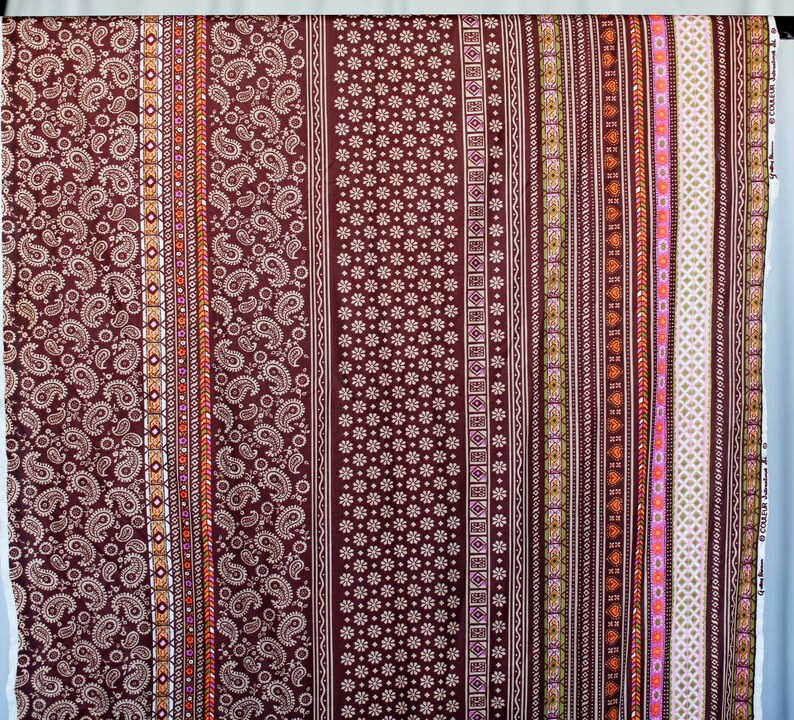 Puede incluir: Una tela marr&oacute;n con un patr&oacute;n repetitivo de paisley, flores y formas geom&eacute;tricas. La tela tiene un dise&ntilde;o de rayas verticales con diferentes colores, incluyendo blanco, naranja, rosa y verde.