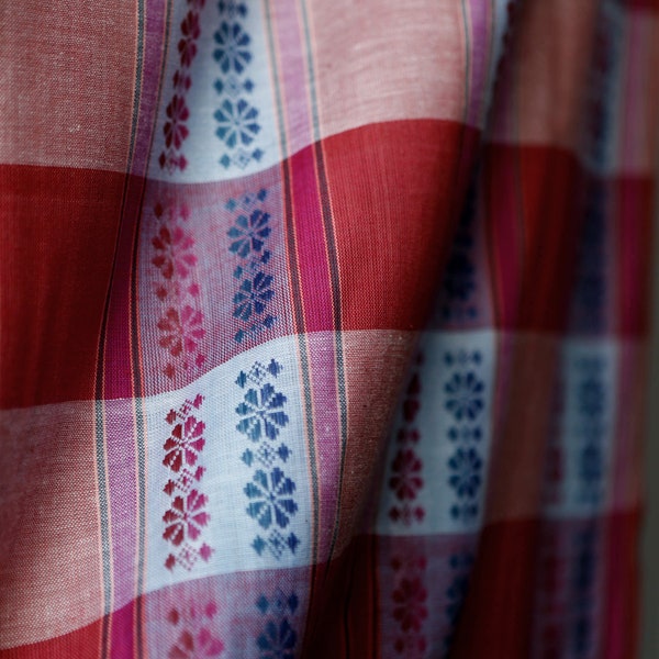 Coral rust and pink checked fabric with embroidered blue purple circular flower- like pattern