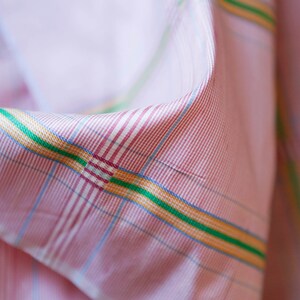 May include: Pink fabric with a checkered pattern in shades of pink, blue, yellow, and green.