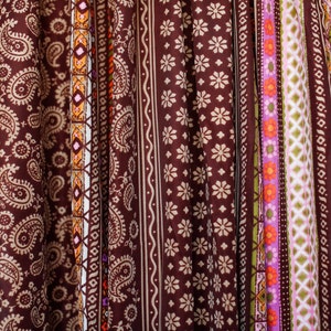 Puede incluir: Primer plano de una tela marr&oacute;n con una variedad de patrones coloridos. La tela presenta dise&ntilde;os de paisley, geom&eacute;tricos y florales.