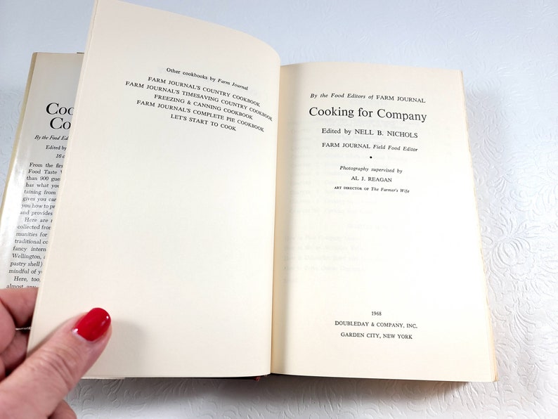 May include: Open book titled "Cooking for Company" by the Food Editors of Farm Journal. The book's pages are cream-colored with black text. The cover is partially visible, showing the title and author.