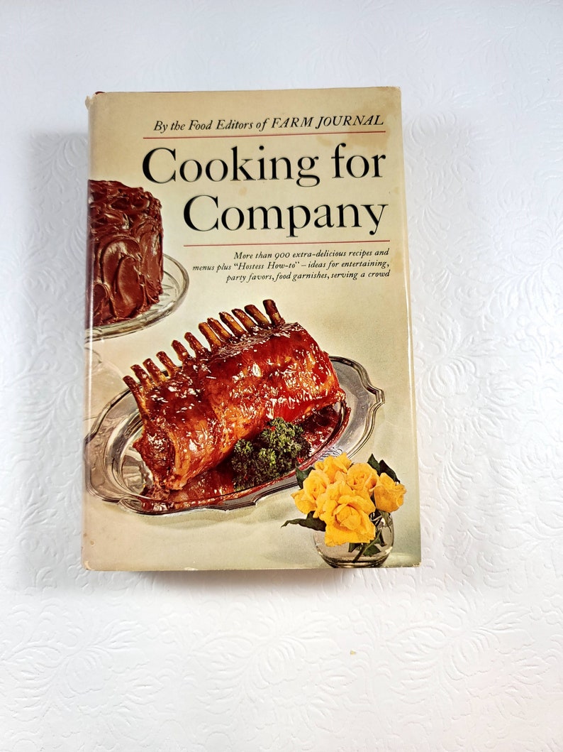 May include: A vintage cookbook titled "Cooking for Company" by the Food Editors of Farm Journal. The cover features images of a roasted meat dish, a chocolate cake, and yellow roses in a glass vase. The book promises extra-delicious recipes and entertaining ideas.