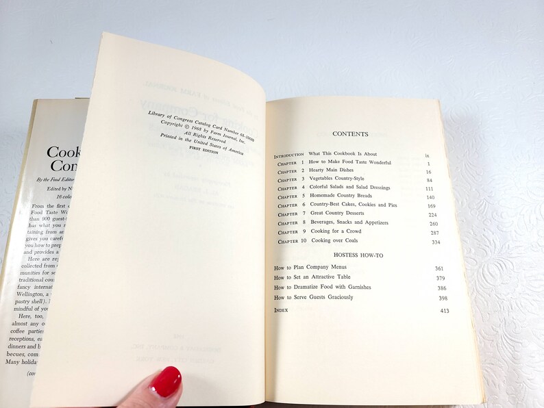 May include: Open cookbook with the title "Cookery, the Food Editor", showing the contents page and the introduction. The pages are off-white with black text. The book is open to reveal the table of contents.