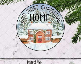 May include: A round ornament featuring a watercolor illustration of a brick house covered in snow, surrounded by pine trees. The text reads "OUR FIRST CHRISTMAS IN OUR NEW HOME" in black lettering. The design is set against a white background.