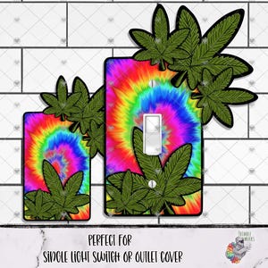 Peut inclure: Deux plaques d'interrupteur avec un motif tie-dye aux couleurs vives de l'arc-en-ciel. Chaque plaque est ornée de feuilles de cannabis vertes. Le texte en bas indique "PERFECT FOR SINGLE LIGHT SWITCH OR OUTLET COVER."