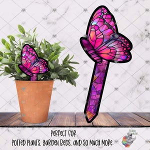 May include: Two pink and purple stained glass butterfly garden stakes. The larger stake is taller and has a more detailed design. The smaller stake is shorter and has a simpler design. The text "Perfect for potted plants, garden beds, and so much more" is at the bottom of the image.