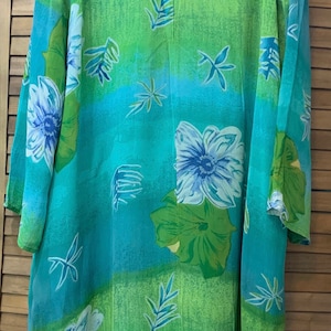 Puede incluir: Una camisa de manga larga con estampado floral azul y verde con cierre de botones.