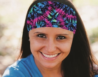 May include: A woman with long dark hair is wearing a blue tie-dye headband. The headband has a pink, blue, and green pattern. She is smiling and wearing a blue shirt.