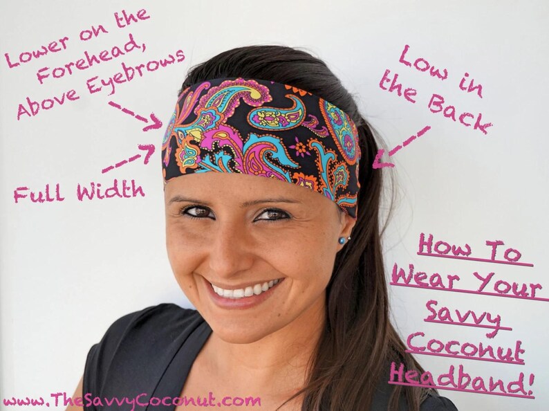 May include: A woman wearing a black and pink paisley patterned headband. The headband is positioned low on the forehead, above the eyebrows, and low at the back. The text "How To Wear Your Savvy Coconut Headband!" is written in pink on a white background.