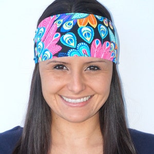 Peut inclure: Une femme aux longs cheveux noirs porte un bandeau noir avec un motif de plumes de paon color&eacute;. Le bandeau est fait d'un mat&eacute;riau doux et extensible, id&eacute;al pour garder les cheveux hors du visage.