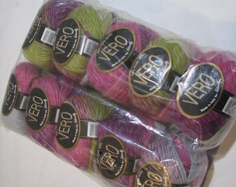 May include: A pack of eight balls of yarn in shades of green, pink and purple. The yarn is labelled "VERO 100% Pure Wool Made in Italy for Hand Knitting".