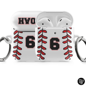 May include: White AirPods case with a baseball design. The case features red stitching, the number 6 in black with a red outline, and the name "NOAH" in red and black. Includes a silver carabiner clip.