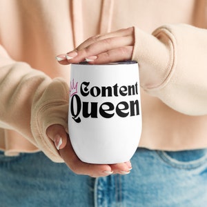 May include: White stainless steel tumbler with a pink crown and the text "Content Queen" in black.