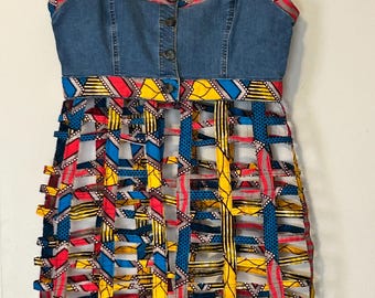 Una tunica in denim unica nel suo genere, un'opera d'arte indossabile che fonde lo stile street contemporaneo con le ricche tradizioni tessili africane.