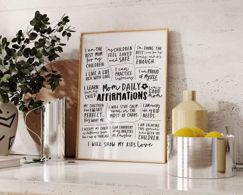 May include: A framed print with the words "Mom Daily Affirmations" in black script. The print includes positive affirmations for mothers, such as "I am the best mom for my children" and "I will show my kids love."