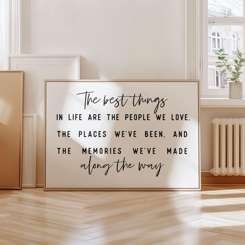 May include: A black and white inspirational quote on a framed canvas with a gold frame. The quote reads: "The best things in life are the people we love. The places we've been. And the memories we've made along the way."