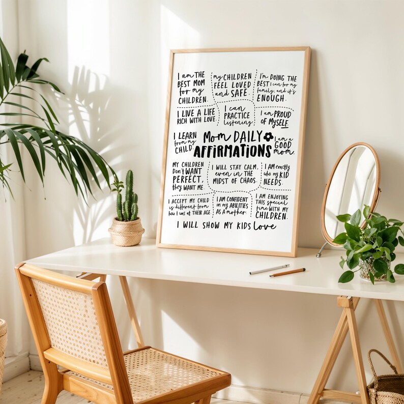 May include: A framed print with the text "Mom Daily Affirmations" in black script. The print is on a white background and includes affirmations such as "I am the best mom" and "I will show my kids love." The frame is light brown.