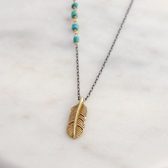 Little golden feather on black chain