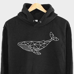 K&ouml;nnte beinhalten: Schwarzer Hoodie mit einem wei&szlig;en geometrischen Wal-Design auf der Vorderseite.