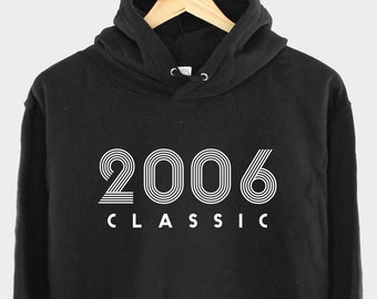 Pode incluir: Camisola de capuz preta com texto branco que diz "2006 CLASSIC".