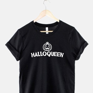 Peut inclure: T-shirt noir avec un graphique blanc d'une citrouille avec une couronne et le texte "Halloqueen".