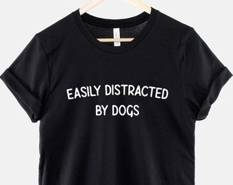 May include: Black t-shirt with white text that reads "Easily Distracted By Dogs".