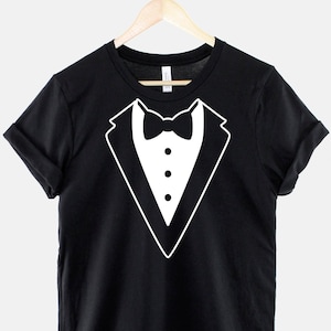 May include: Black t-shirt with a white tuxedo graphic on the front. The tuxedo graphic includes a bow tie and two buttons.
