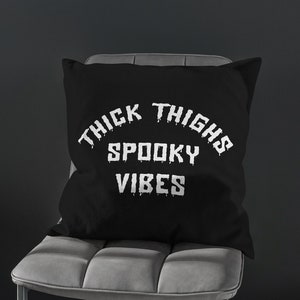 May include: Black throw pillow with white text that reads "Thick Thighs Spooky Vibes".