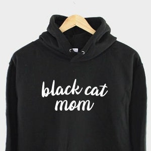 May include: Black hoodie with white text that says "black cat mom".