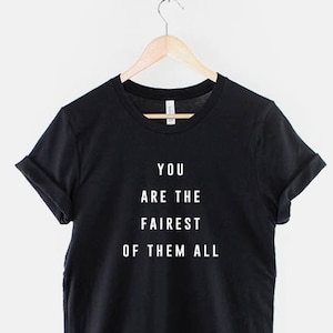 May include: Black t-shirt with white text that reads "You are the fairest of them all."