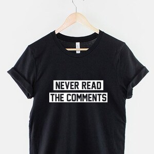 Puede incluir: Camiseta negra con texto blanco que dice "NUNCA LEAS LOS COMENTARIOS".