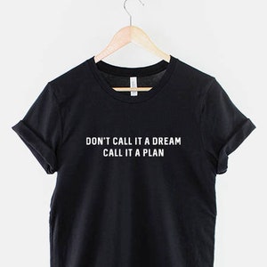 K&ouml;nnte beinhalten: Schwarzes T-Shirt mit wei&szlig;em Text, der "Nenn es nicht einen Traum, nenn es einen Plan" lautet.