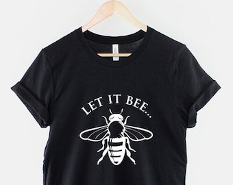 Może przedstawiać: Czarny T-shirt z białym napisem "Let it bee..." i białą sylwetką pszczoły.