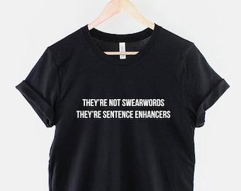 May include: Black t-shirt with white text that reads "They're not swearwords They're sentence enhancers".