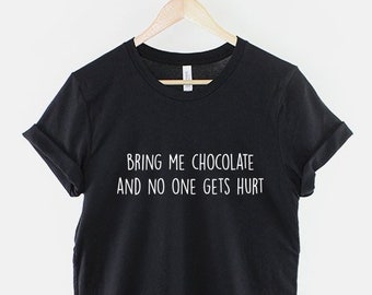 Peut inclure: T-shirt noir avec un texte blanc qui dit "Apportez-moi du chocolat et personne ne sera blessé."