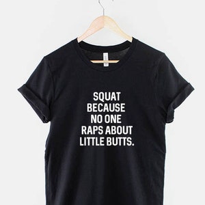 Pode incluir: Camiseta preta com texto branco que diz "Squat because no one raps about little butts."