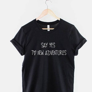 May include: Black t-shirt with white text that reads "Say yes to new adventures".