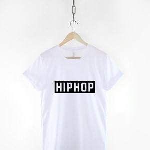 May include: White t-shirt with black text that says "HIPHOP" in a rectangle.