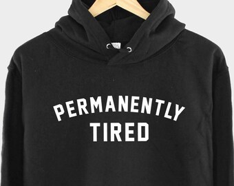 May include: Black hooded sweatshirt with the text "PERMANENTLY TIRED" in white.