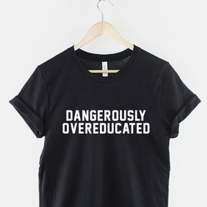 Puede incluir: Camiseta negra con texto blanco que dice "Dangerously Overeducated".