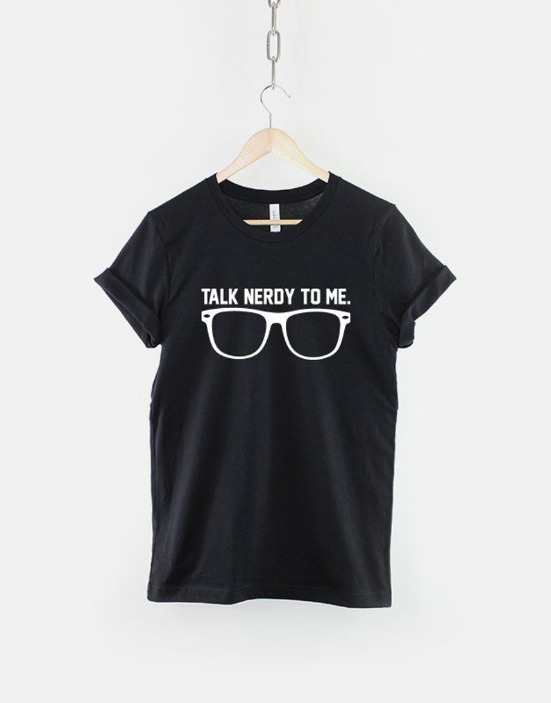 May include: Black t-shirt with white text that reads "Talk Nerdy To Me."  The text is above a pair of white eyeglasses.