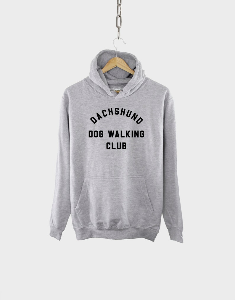 May include: A gray hooded sweatshirt with the text "Dachshund Dog Walking Club" printed on the front.