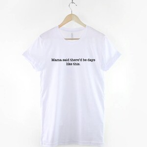 May include: White t-shirt with black text that reads "Mama said there'd be days like this."
