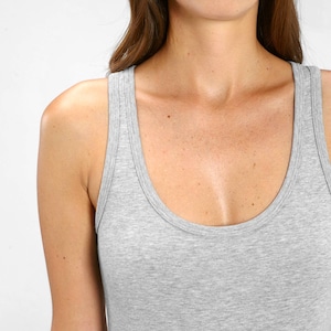 May include: A gray sleeveless tank top with a scoop neck.