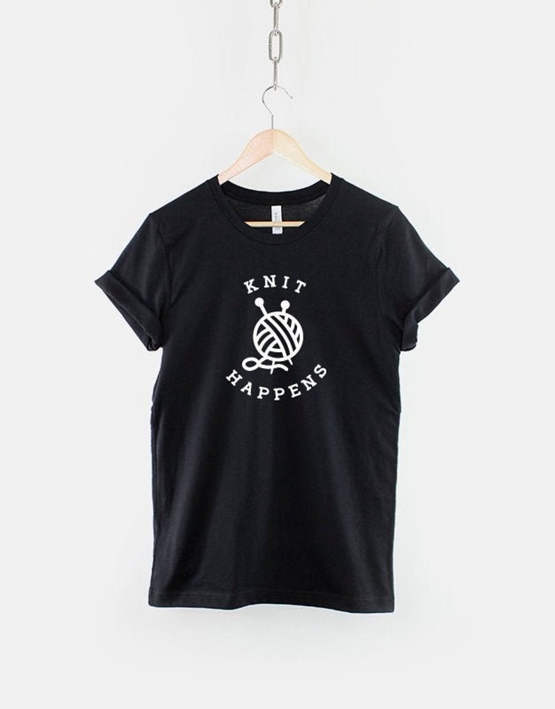 May include: Black t-shirt with white text that reads "Knit Happens" and a graphic of a ball of yarn with knitting needles.