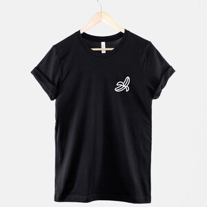 May include: A black t-shirt with a white outline of a banana on the left chest.