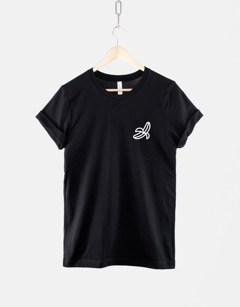 May include: A black t-shirt with a white outline of a banana on the left chest.