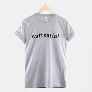 May include: A heather grey t-shirt with the word "antisocial" printed in black gothic font.
