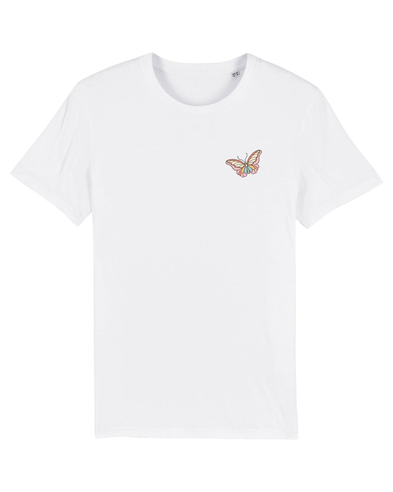 May include: White t-shirt with a small embroidered butterfly design in pink, yellow, and blue.