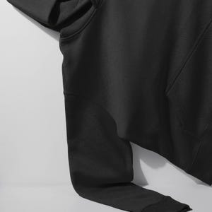 A black hoodie is shown in the image, with a white background.